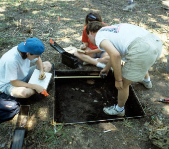 Three students map and record the precise location of each artifact uncovered in their 1x1 meter square excavation unit the Quarry Creek site (1991)