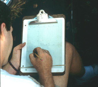 A student draws a detailed plan map of the the artifacts uncovered in their excavation unit at the Quarry Creek site (1991)