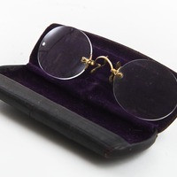 The eyeglasses on display leaning up against the case