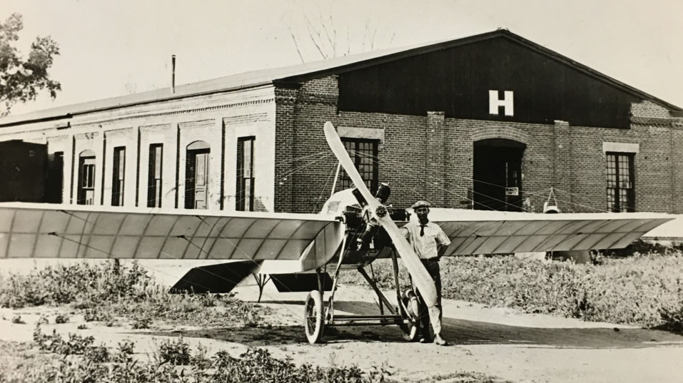 Cessna stands in front of his 1917 plane, The Comet, and the J. J. Motor Co. factory which it was built.