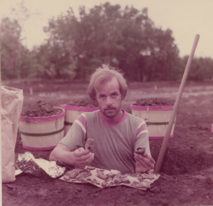 Holidome excavation volunteer holding artifact finds.