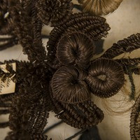 A flower on the hair wreath made of brunette hair