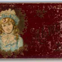 Annie Baker's autograph book, maroon cover featuring a young girl