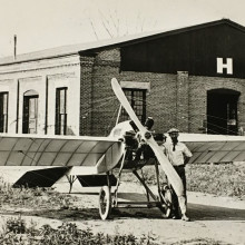 Cessna stands in front of his 1917 plane, The Comet, and the J. J. Motor Co. factory which it was built.